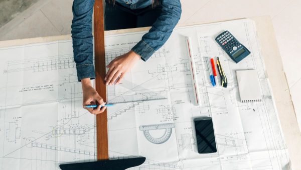 woman-working-with-big-ruler-pen-table